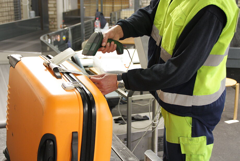 Ein Mitarbeiter scannt mit einem Handscanner einen Beleg ein